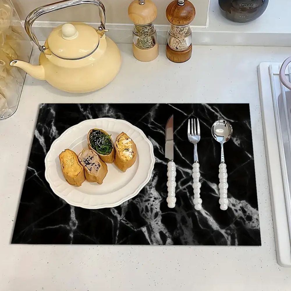 Sort og hvid afdrypningsmåtte med marmormønster på køkkenbordet