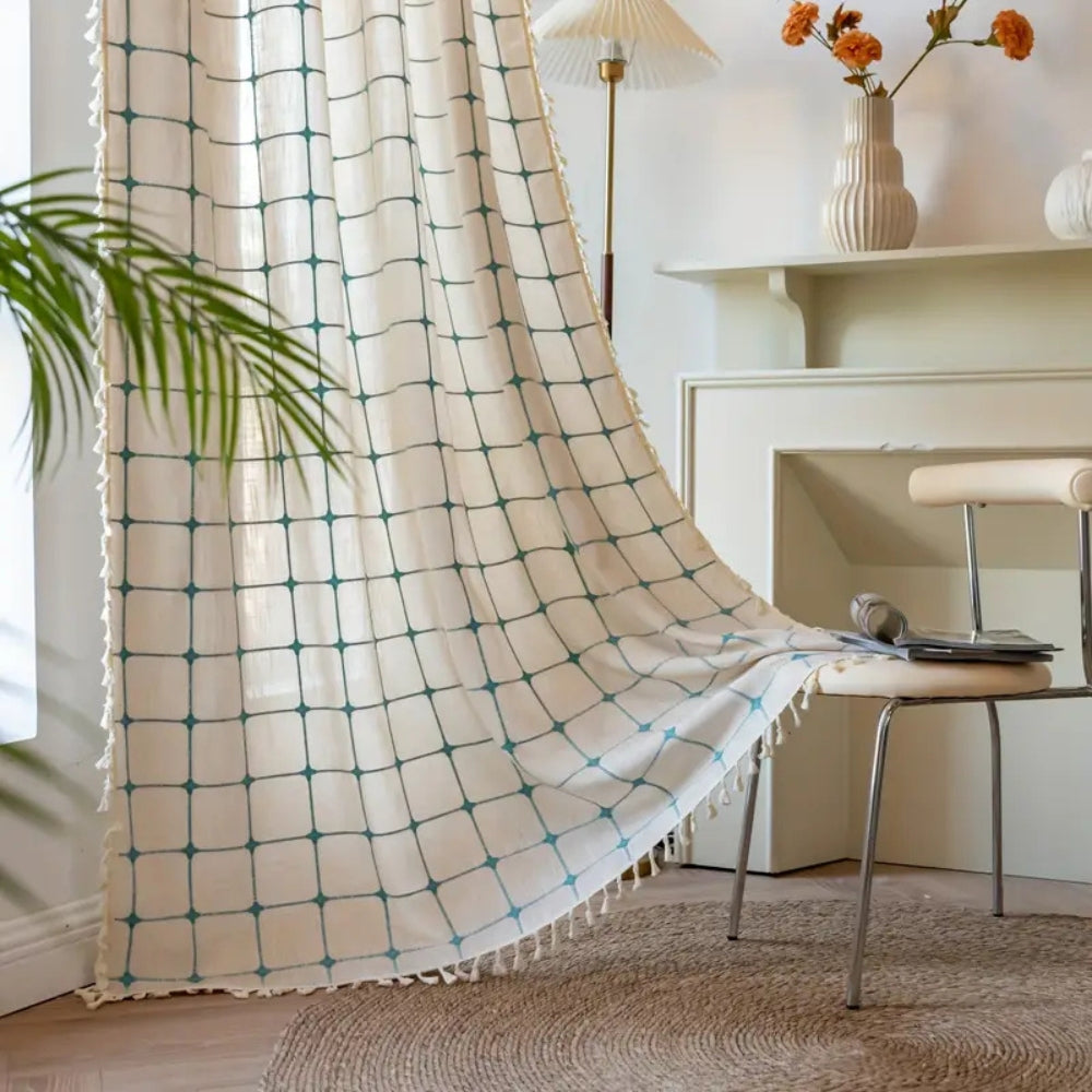 Boho gardin med turkis broderi og kvaster foran et vindue