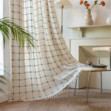 Boho gardin med turkis broderi og kvaster foran et vindue