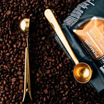 Kaffeske i rustfrit stål med integreret klemme på en kaffepose