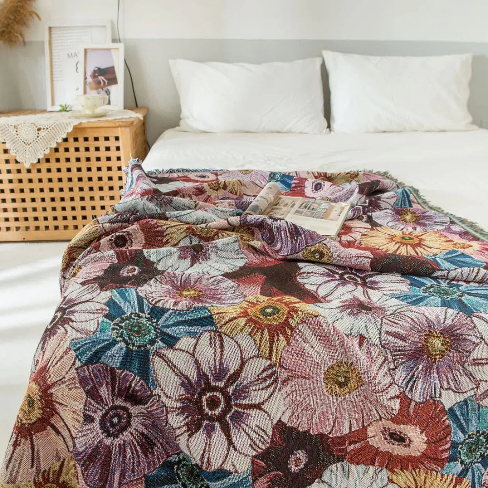 Vævet bomuldstæppe med blomster og kvaster i vintagestil over en sofa