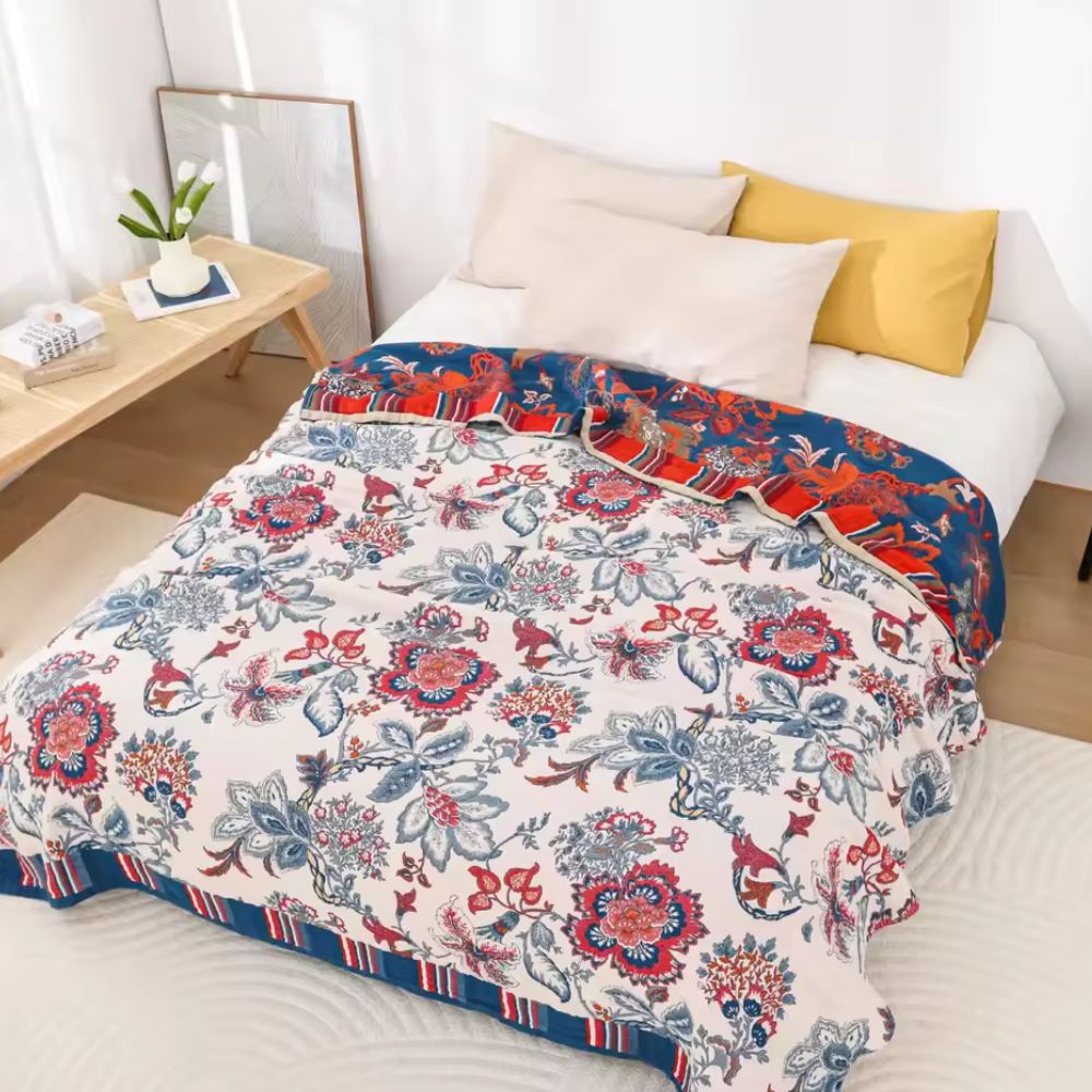 Bomuldstæppe med retro blomsterprint og åndbar struktur over sofa