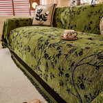 Elegant chenille sofabetræk med blomstermotiv og kvaster på sofa