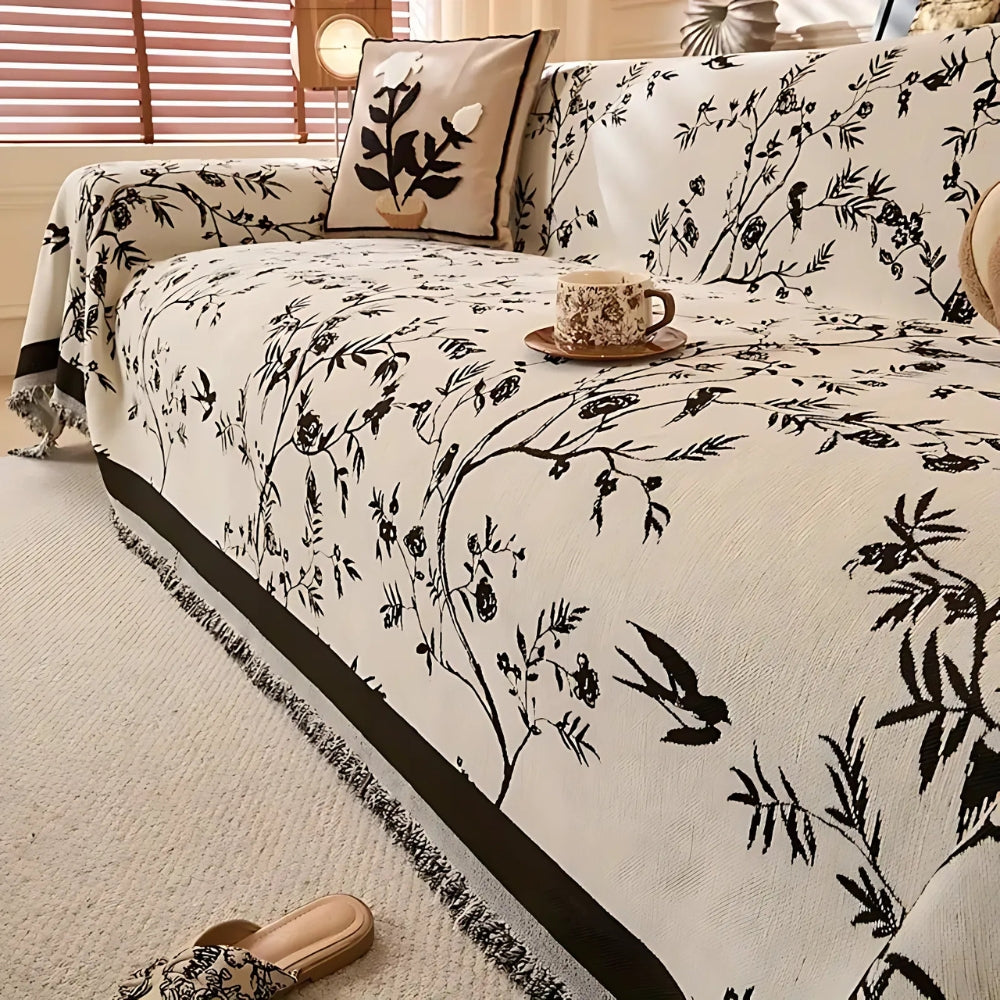 Elegant chenille sofabetræk med blomstermotiv og kvaster på sofa