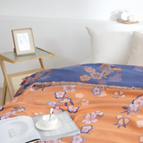 Blødt tæppe med blomstermønster og kvaster over en sofa