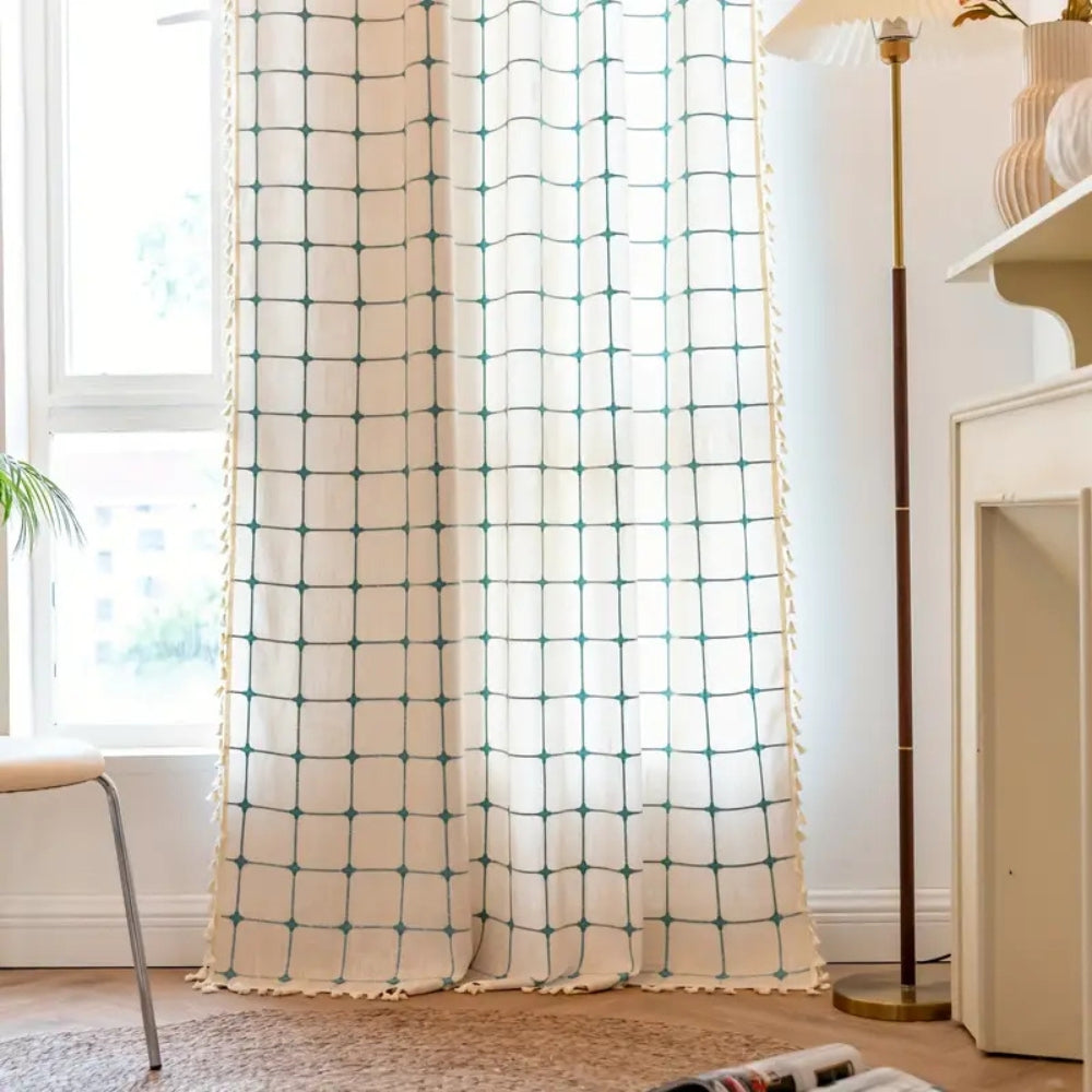 Boho gardin med turkis broderi og kvaster foran et vindue