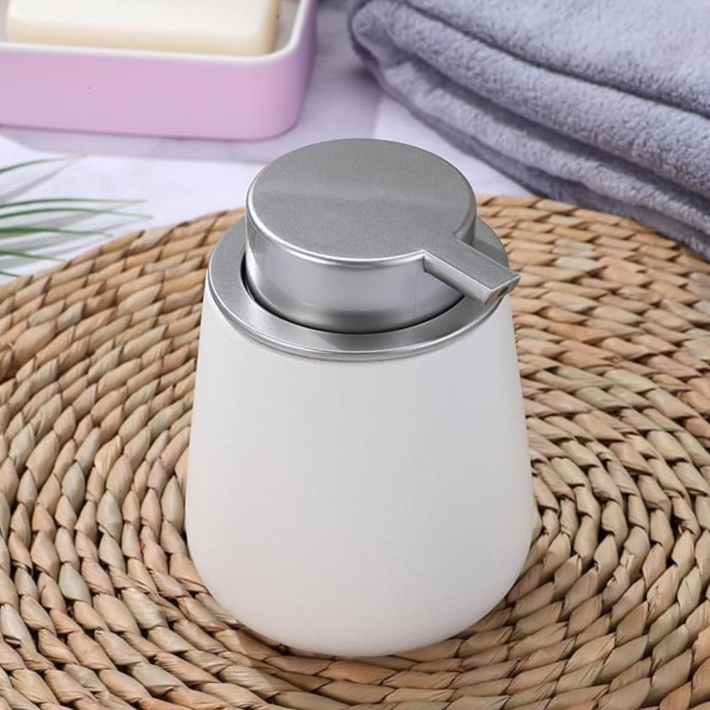 Minimalistisk sæbedispenser i keramik på badeværelsets bordplade