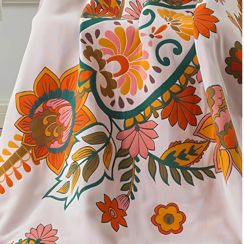 Åndbart håndklæde i bomuldsgaze med blomsterprint foldet på hylde