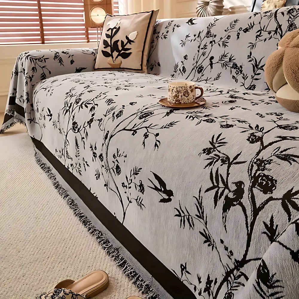 Elegant chenille sofabetræk med blomstermotiv og kvaster på sofa