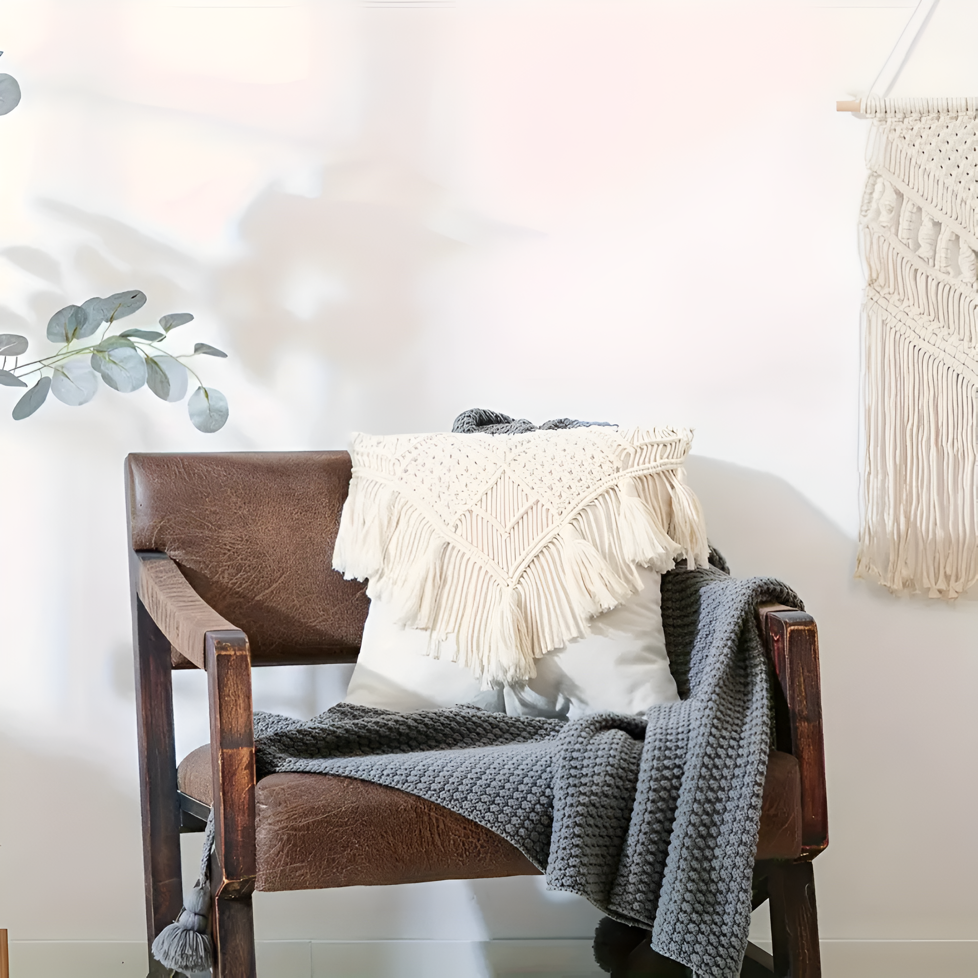 Vintage pudebetræk i jute med makramé og kvaster på en sofa