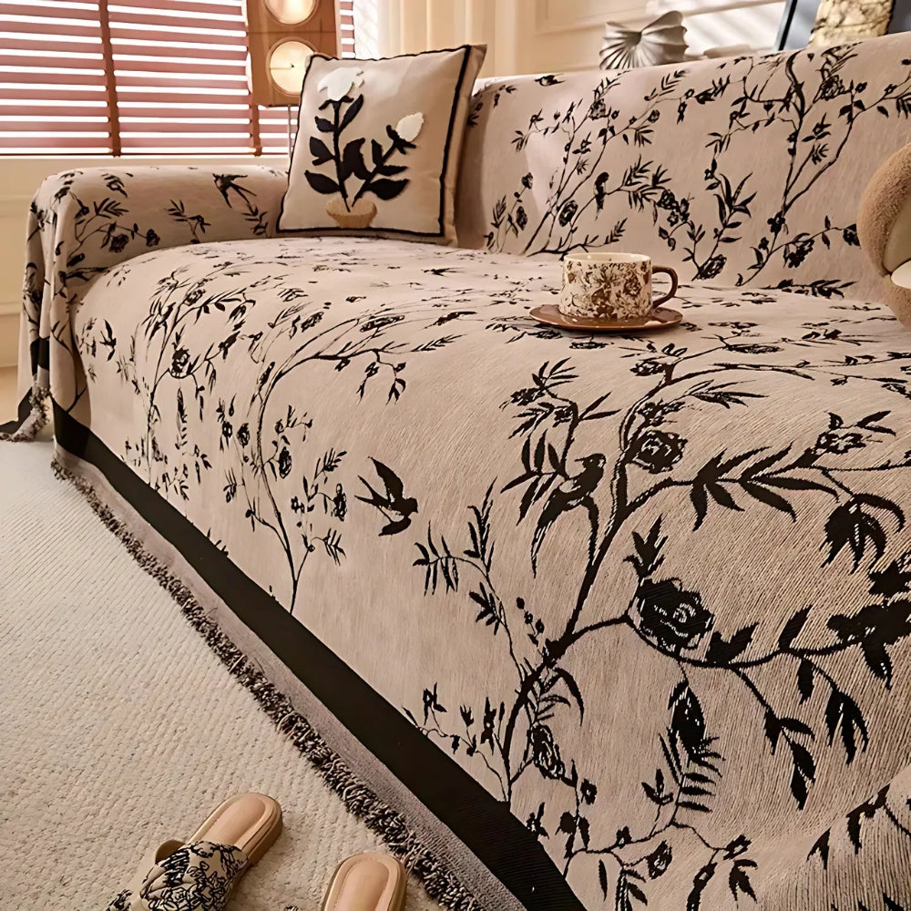 Elegant chenille sofabetræk med blomstermotiv og kvaster på sofa