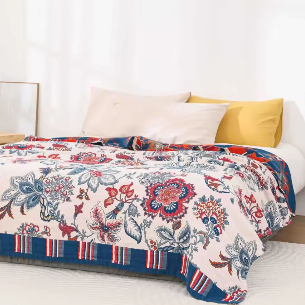 Bomuldstæppe med retro blomsterprint og åndbar struktur over sofa