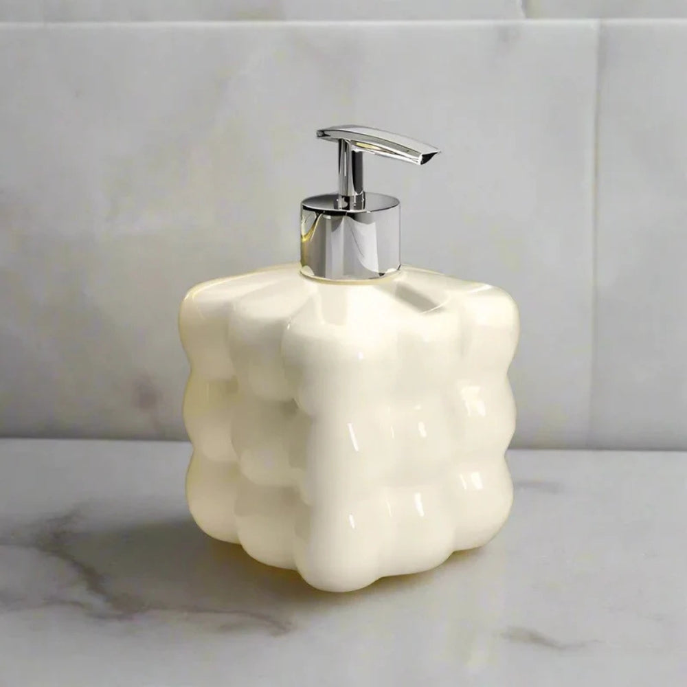 Hvid sæbedispenser i keramik med boblerdesign ved håndvask