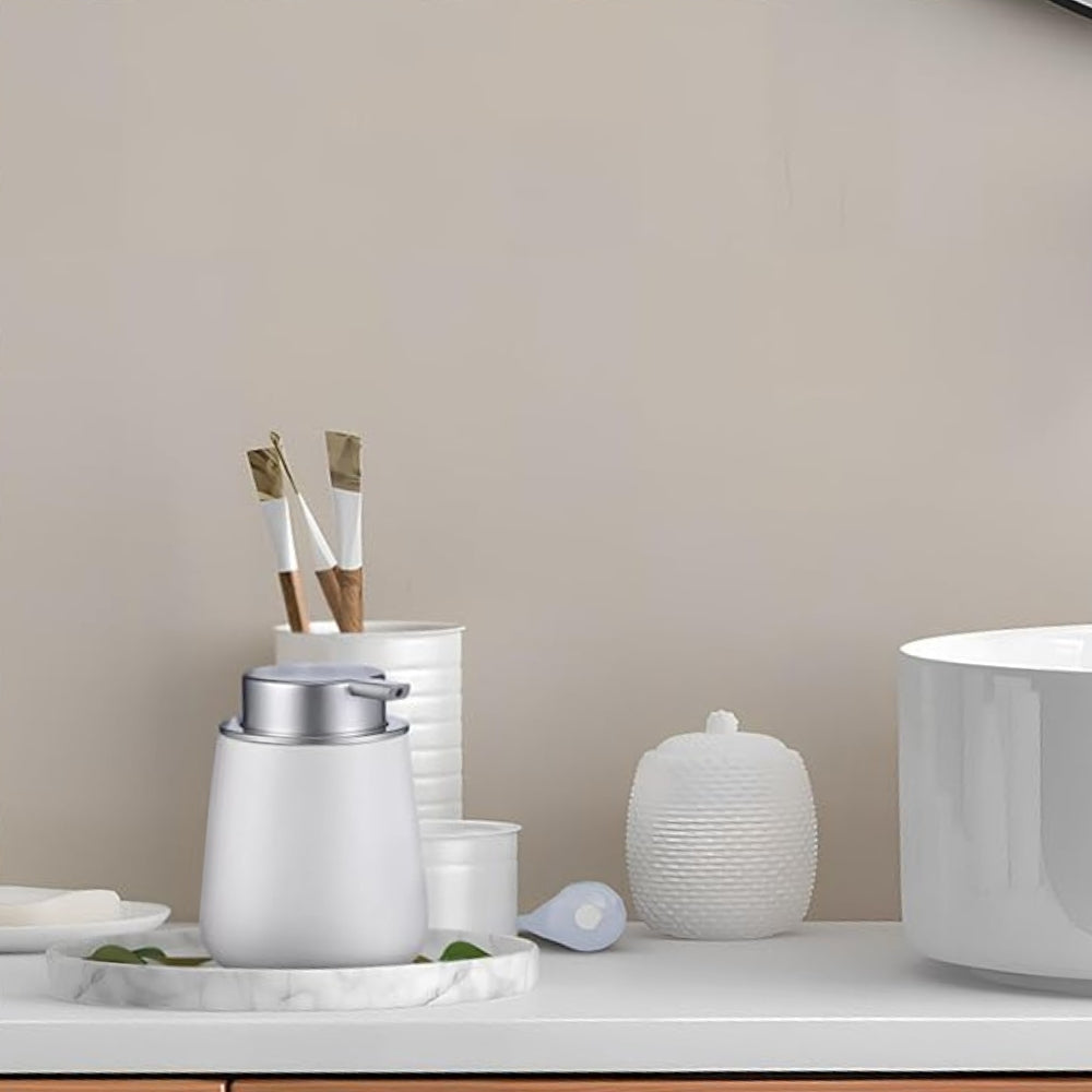 Minimalistisk sæbedispenser i keramik på badeværelsets bordplade