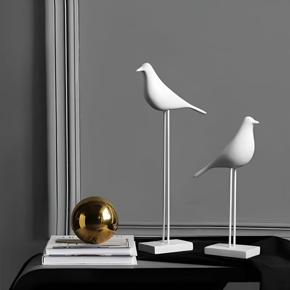 Minimalistiske sorte og hvide fuglefigurer i keramik på en hylde