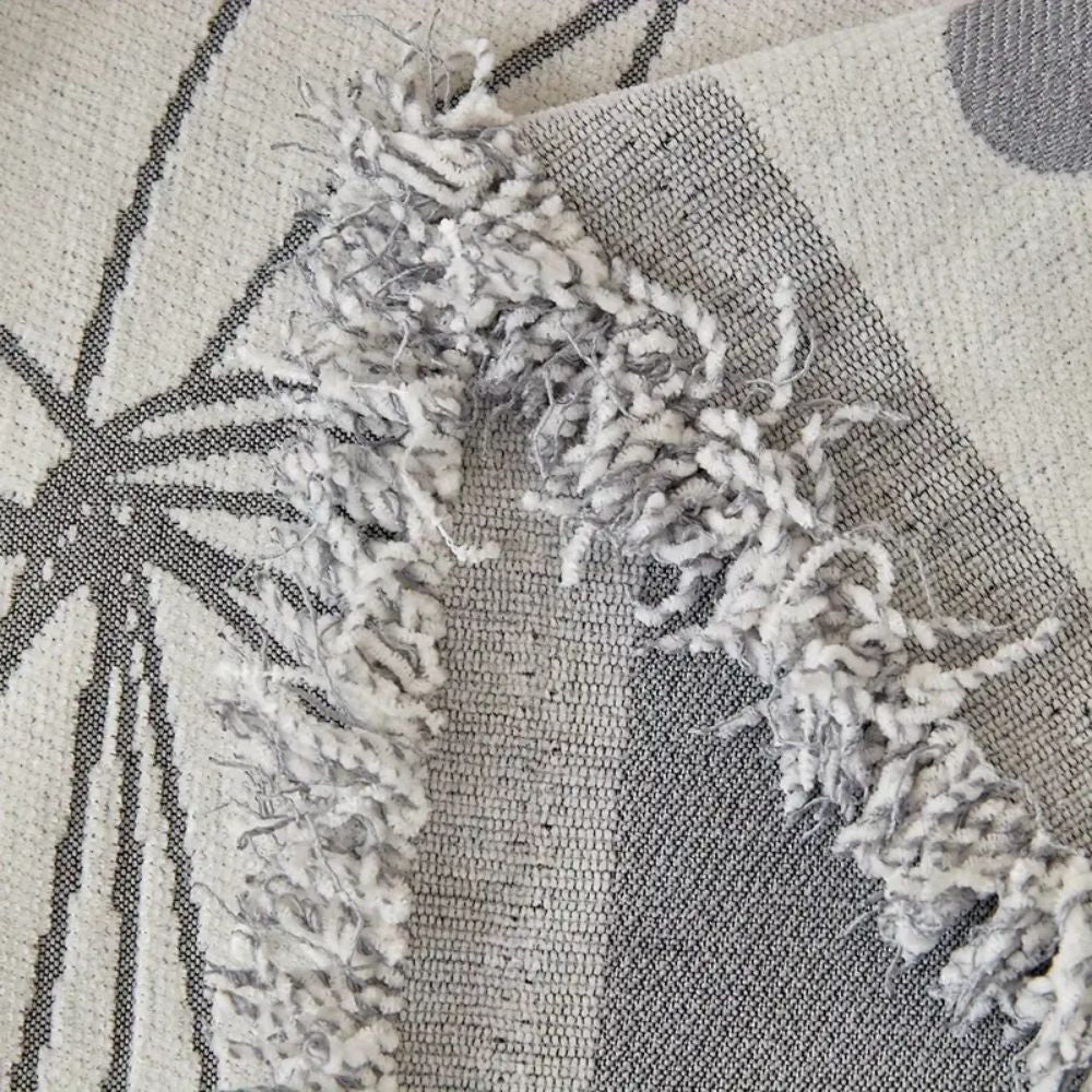 Vendbart sofabetræk i chenille med blomstermønster og kvaster på sofa