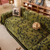 Elegant chenille sofabetræk med blomstermotiv og kvaster på sofa