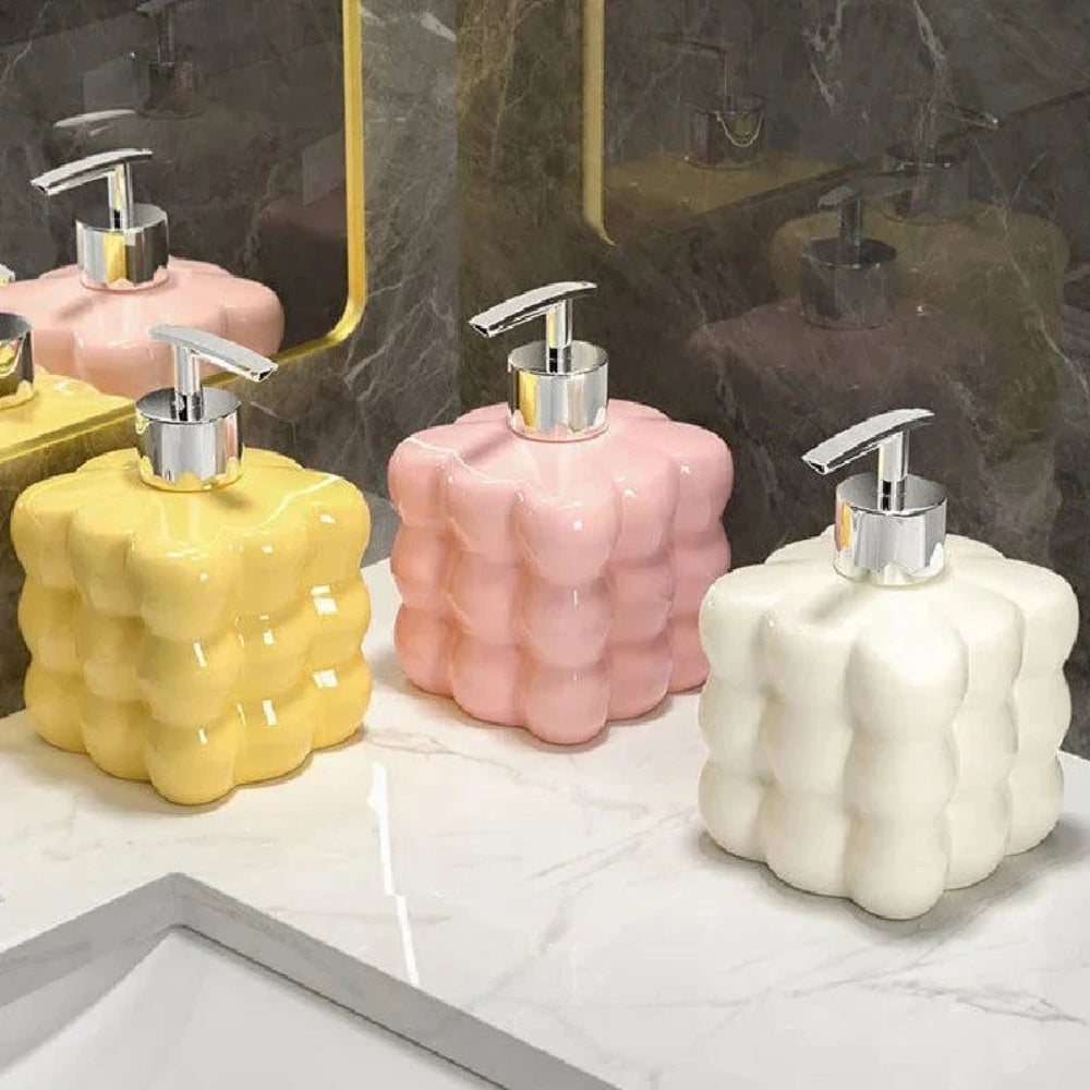Hvid sæbedispenser i keramik med boblerdesign ved håndvask