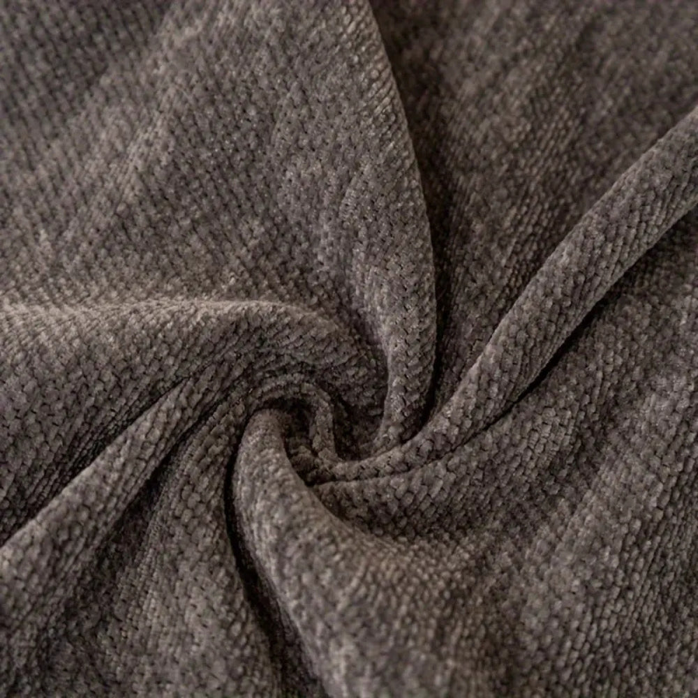 Vendbart chenille sofabetræk med tigermotiv og frynser på sofa