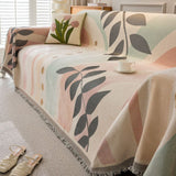 Vendbart sofabetræk i chenille med jacquardmønster og frynser på sofa