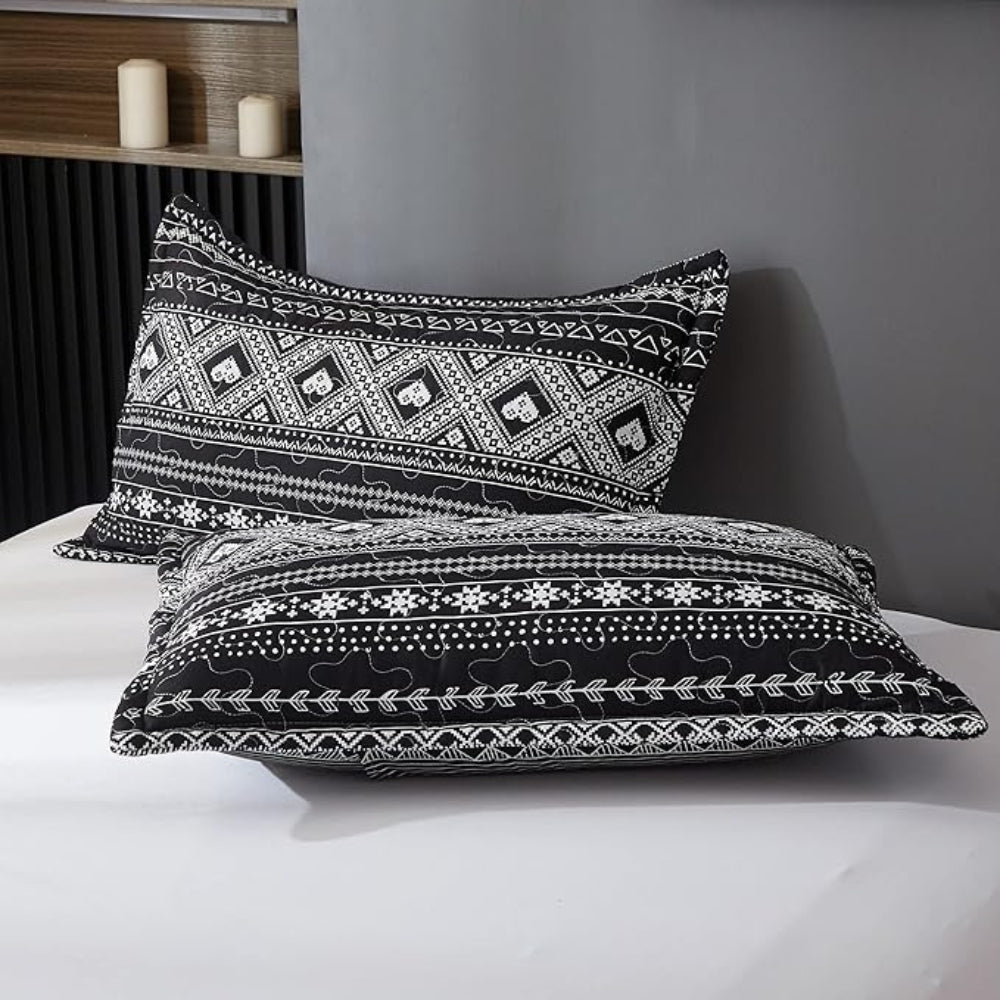 Sort og hvidt boho sengetøj med geometrisk mønster på sengen