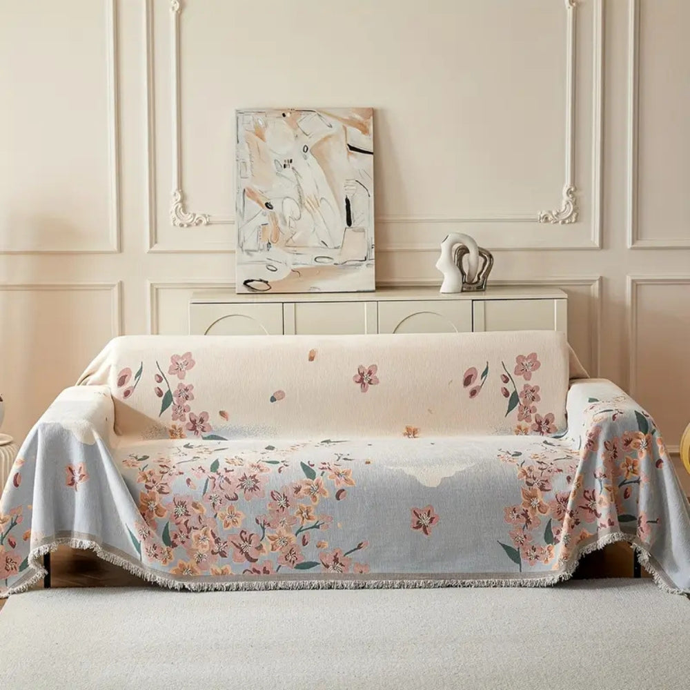 Vendbart sofabetræk med blomsterjacquard og kvaster på sofa