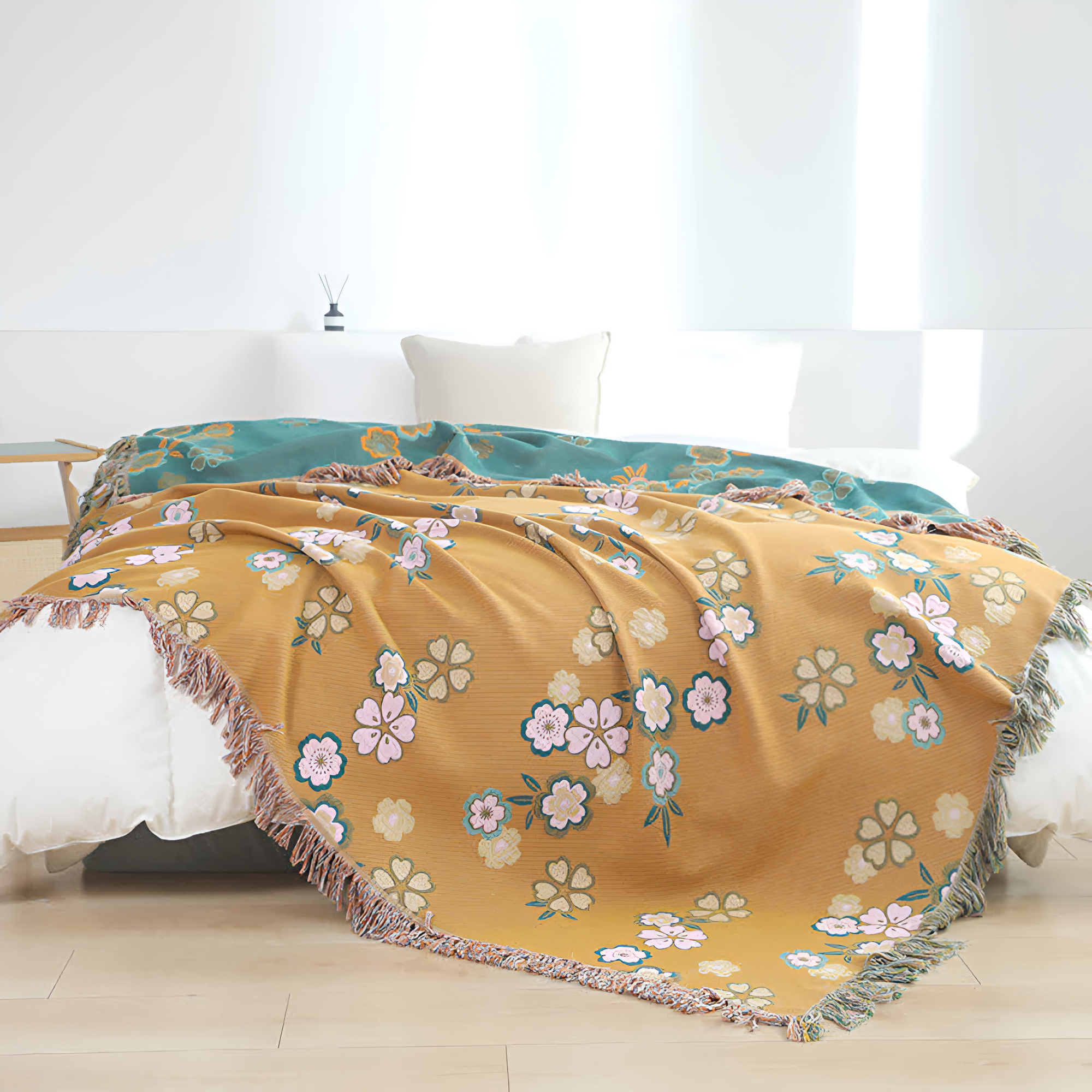Blødt tæppe med blomstermønster og kvaster over en sofa