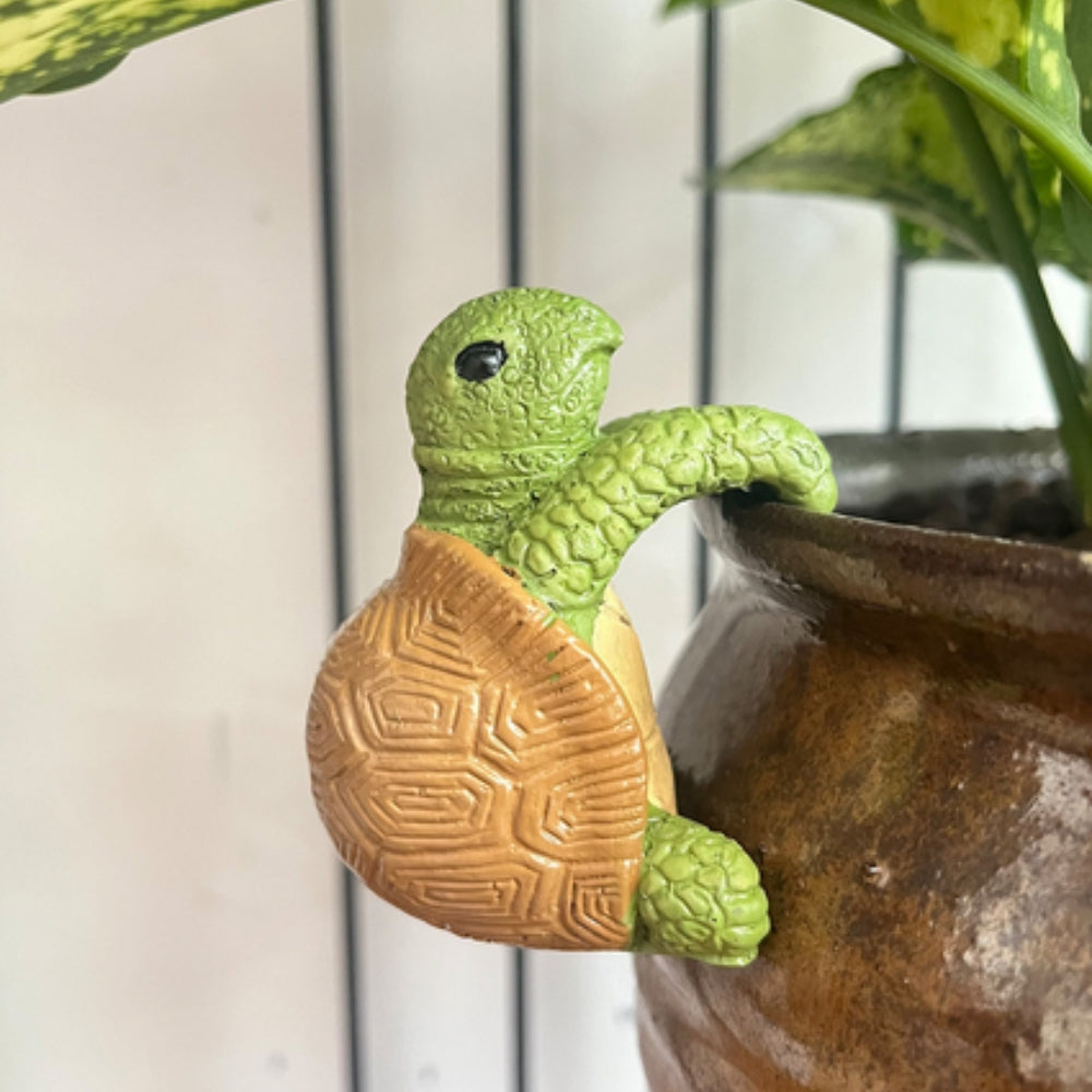 Hængende skildpadde i polyresin på kanten af en urtepotte