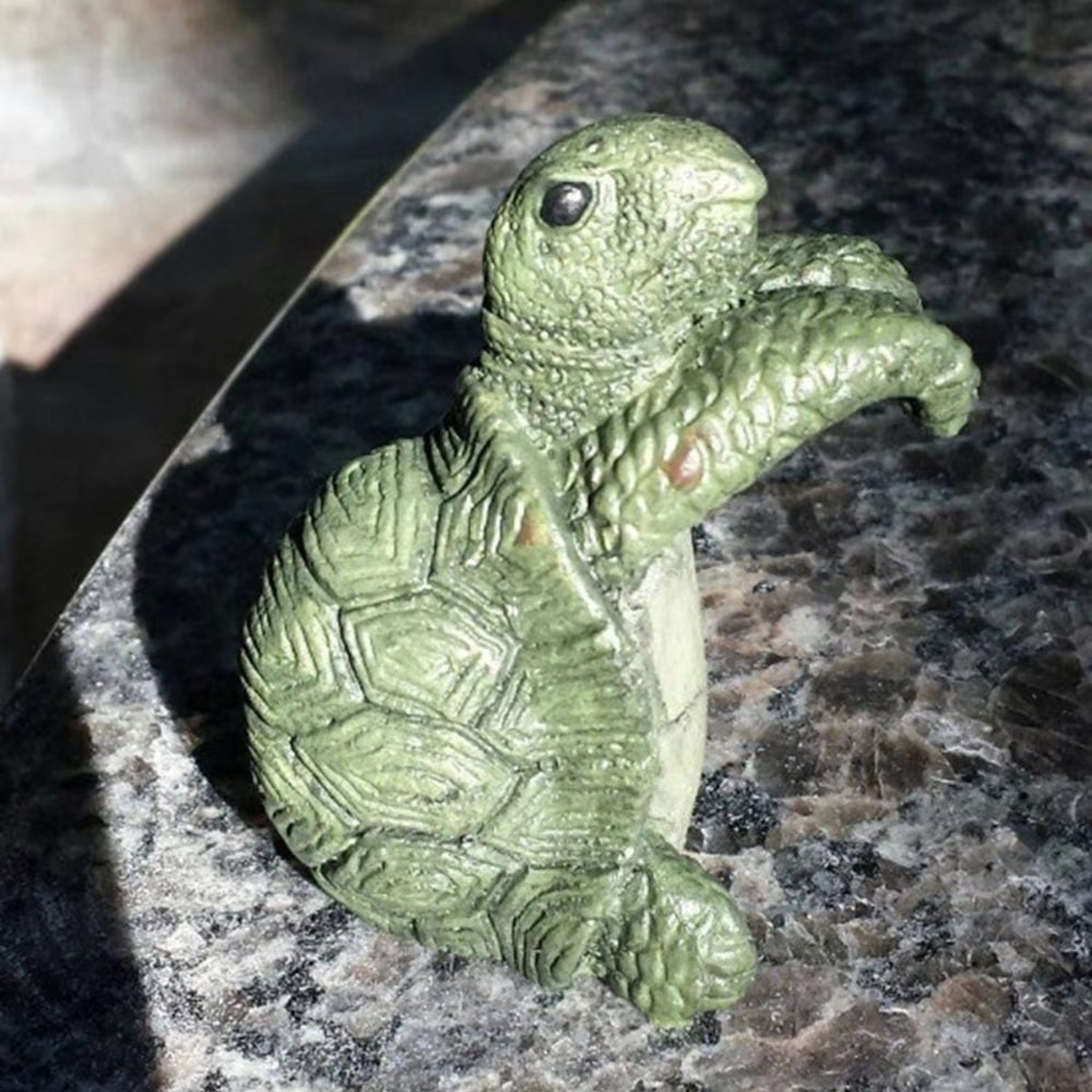 Hængende skildpadde i polyresin på kanten af en urtepotte