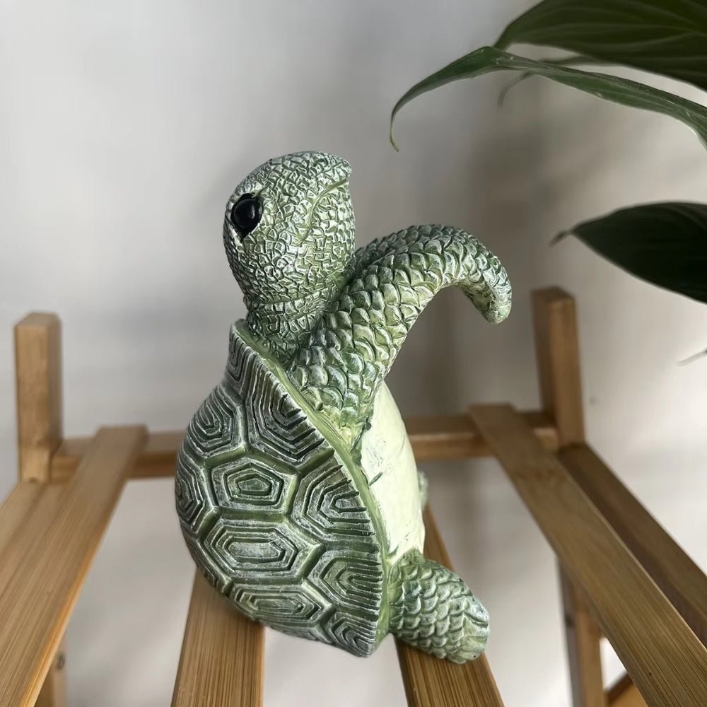Hængende skildpadde i polyresin på kanten af en urtepotte
