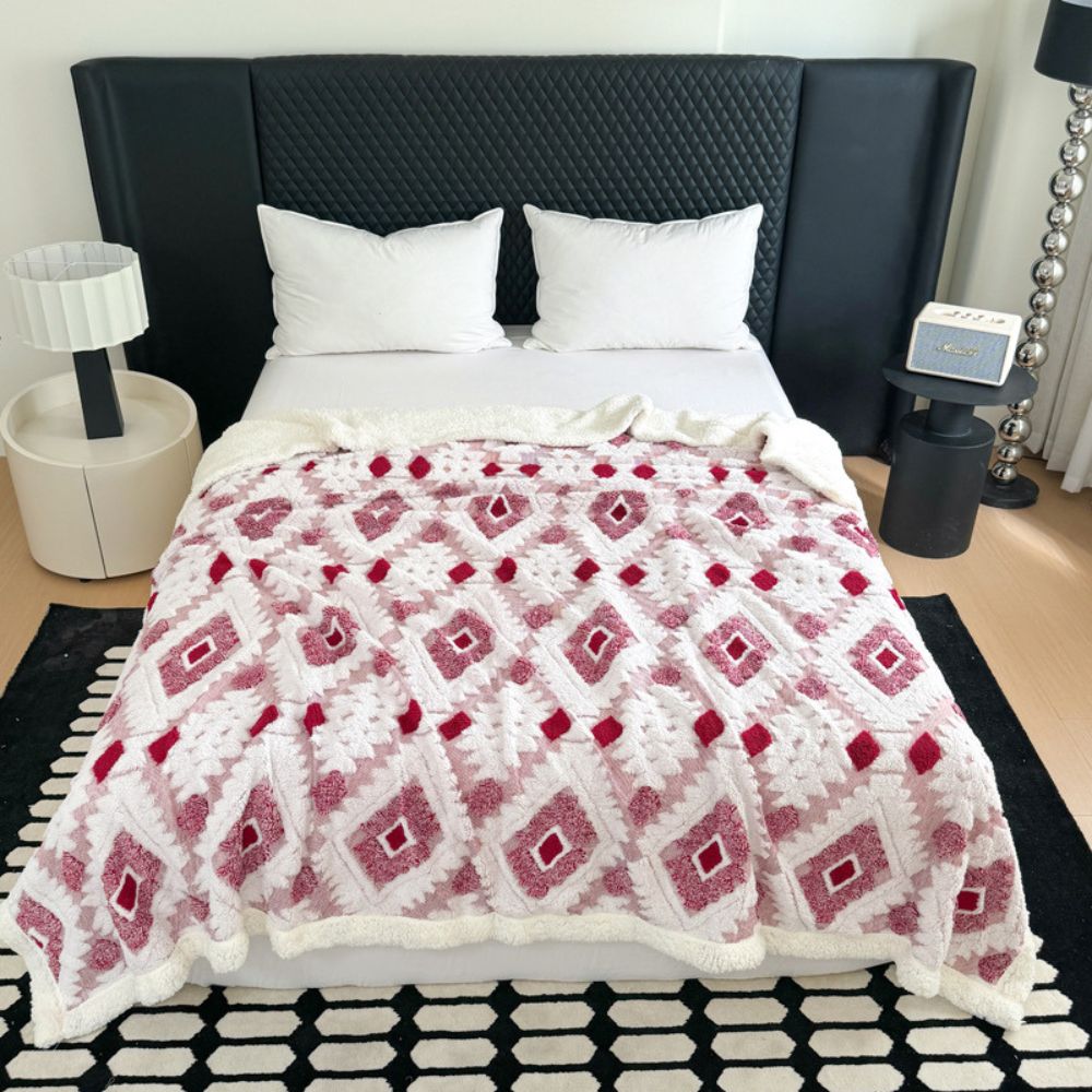 Plaid i to lag med geometrisk rudemønster over en sofa