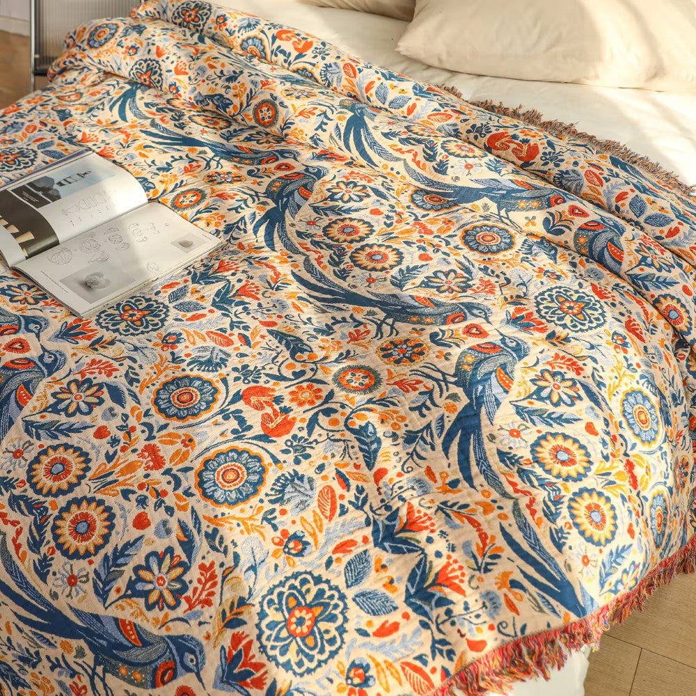 Plaid i bomuld med mønster af fugle og blomster på sofaen