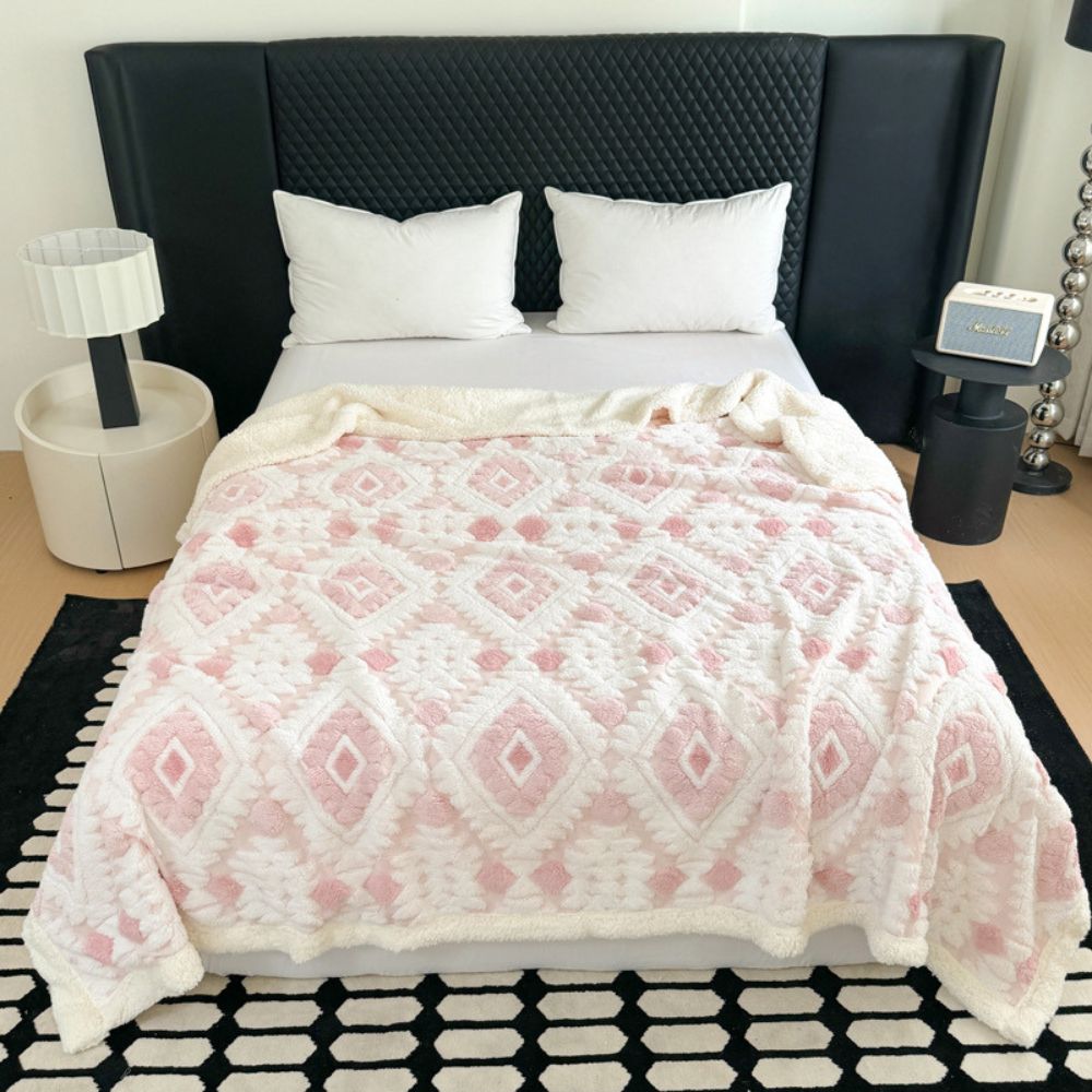 Plaid i to lag med geometrisk rudemønster over en sofa