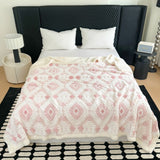 Plaid i to lag med geometrisk rudemønster over en sofa
