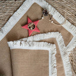 Bordløber i naturlig jute på et dækket spisebord i boho-stil