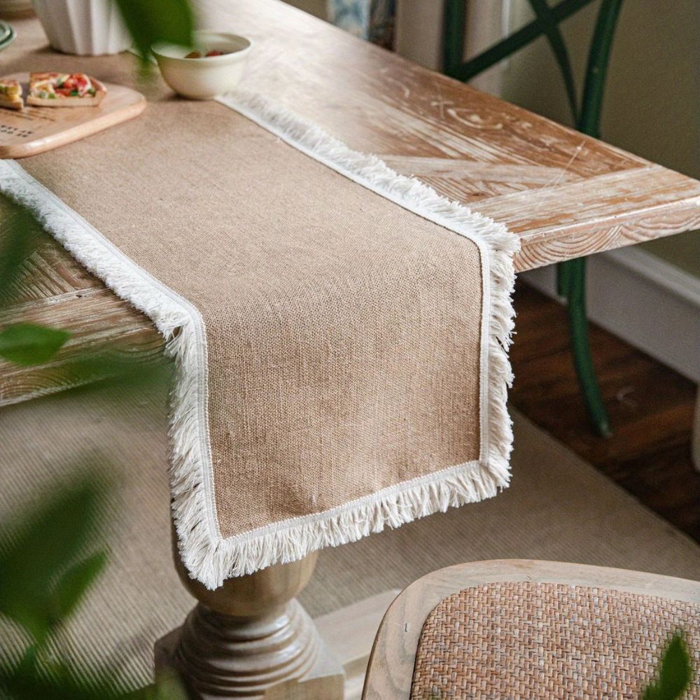 Bordløber i naturlig jute på et dækket spisebord i boho-stil