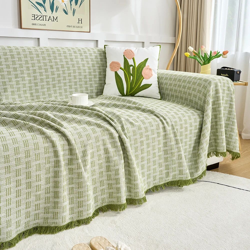 Quiltet sofabetræk med geometrisk mønster og kvaster på sofa