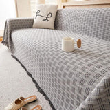 Quiltet sofabetræk med geometrisk mønster og kvaster på sofa
