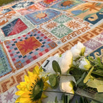 Tykt picnictæppe med frynser og blomstermønster udlagt udendørs