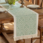 Bordløber med damask-blomstermønster i jordfarver og frynser