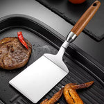 Stegespade i rustfrit stål med træhåndtag til køkken og grill