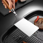 Stegespade i rustfrit stål med træhåndtag til køkken og grill