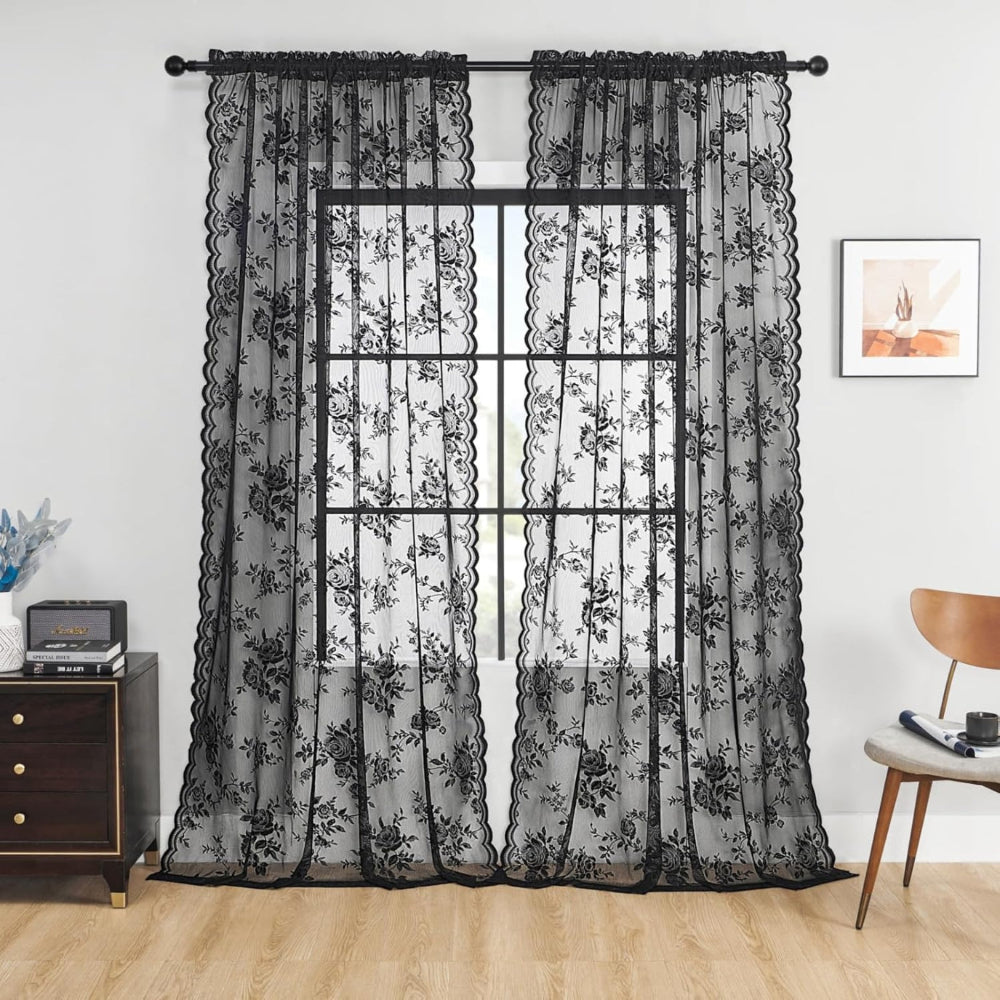 Transparent blondegardin med blomstermotiv foran vindue i stuen