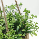 Hængende kunstig plante i vævet kurvepotte på altan