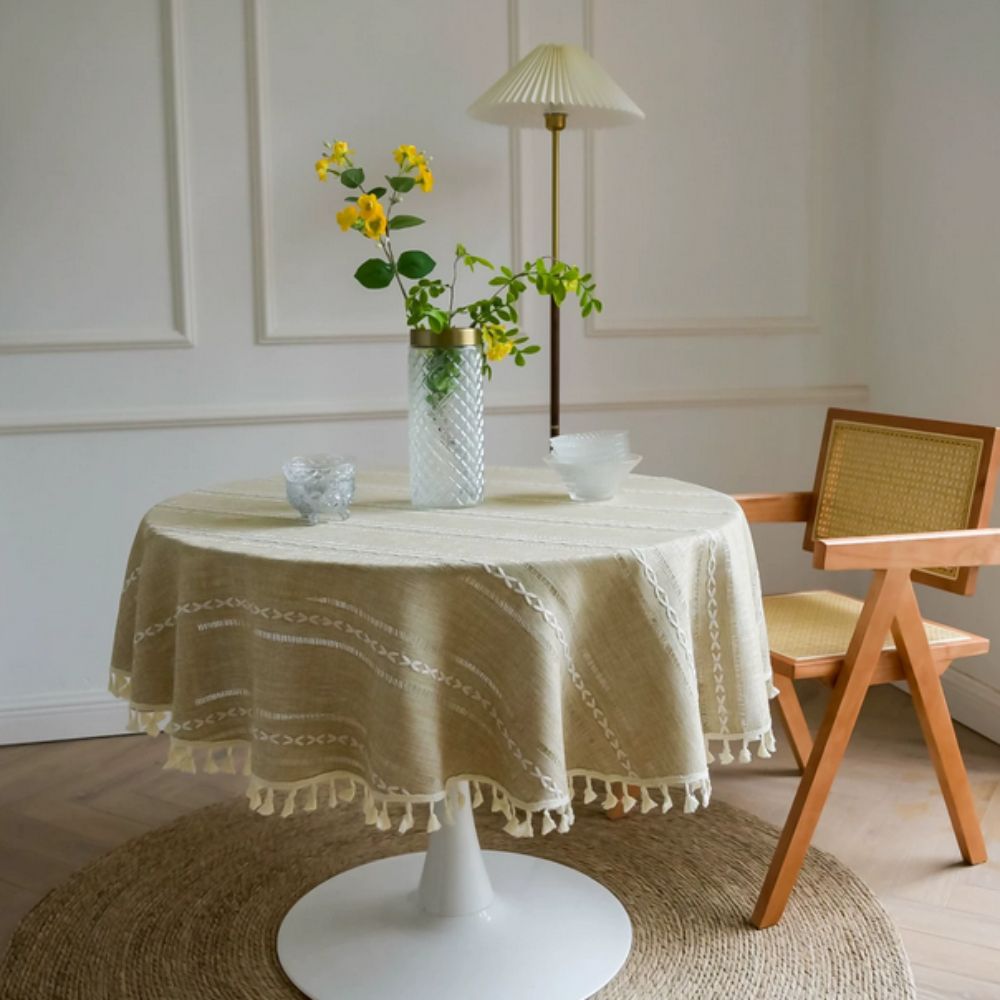 Rund dug med broderi af blade på spisebord