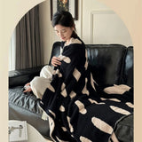 Sort-hvid plaid i fleece med prikker over sofa