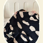 Sort-hvid plaid i fleece med prikker over sofa