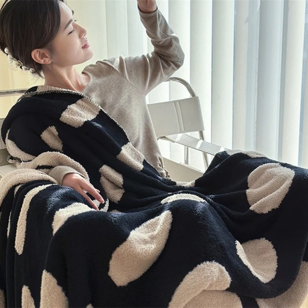 Sort-hvid plaid i fleece med prikker over sofa