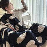 Sort-hvid plaid i fleece med prikker over sofa