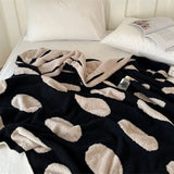 Sort-hvid plaid i fleece med prikker over sofa